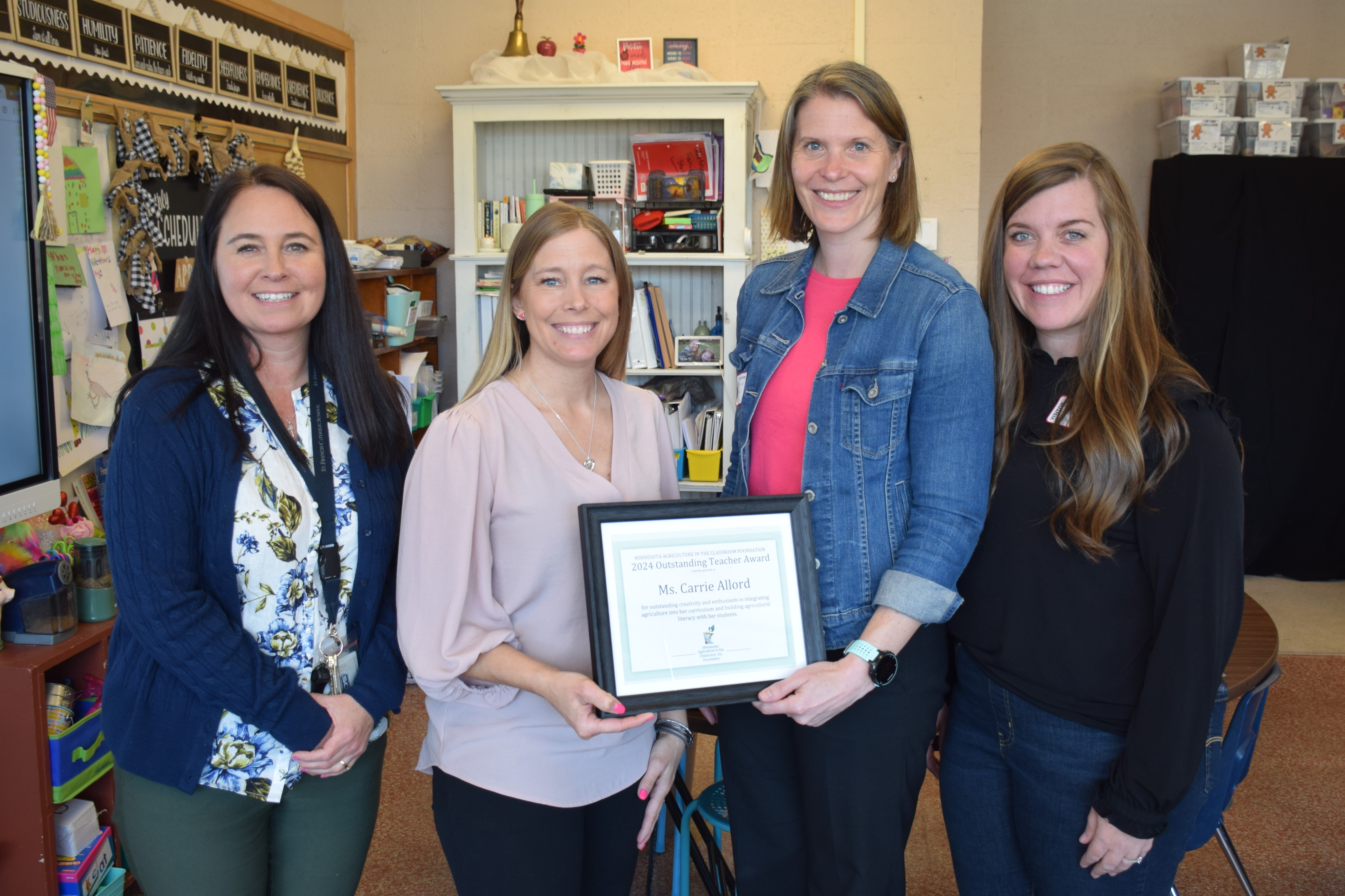 Carrie Allord receives the 2024 MAITC Outstanding Teacher Award from MAITC staff members.