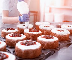 bakery worker topping cakes