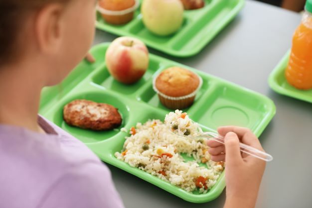 green school food tray with child's hand picking up rice
