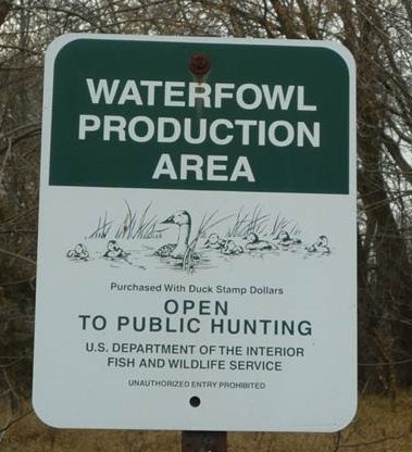 Green and white waterfowl production area sign