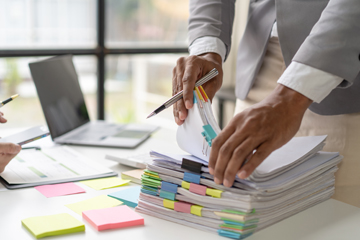 Person looking through stack of papers.