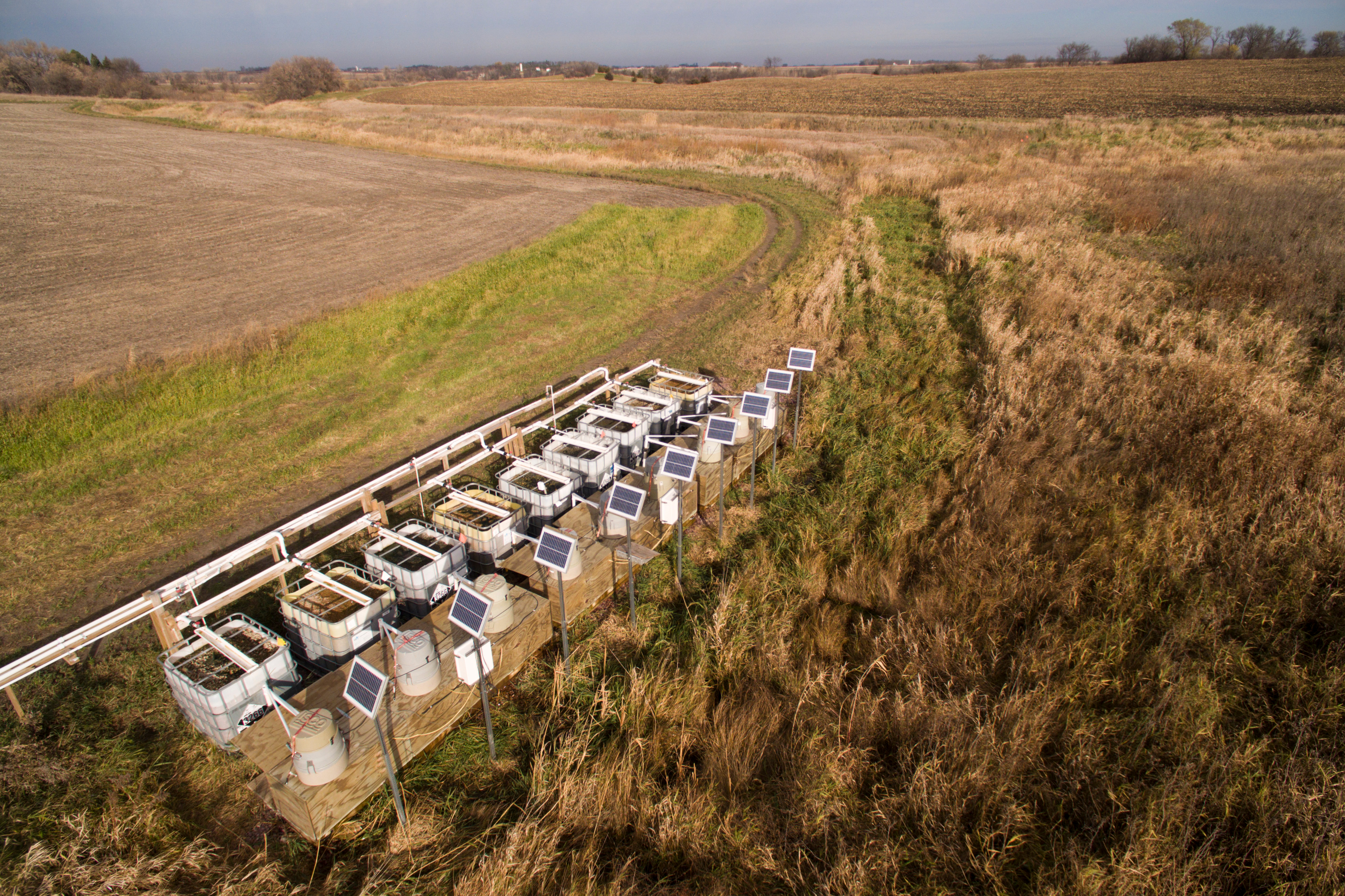Aerial view of modular bioreactor at the edge of a field.