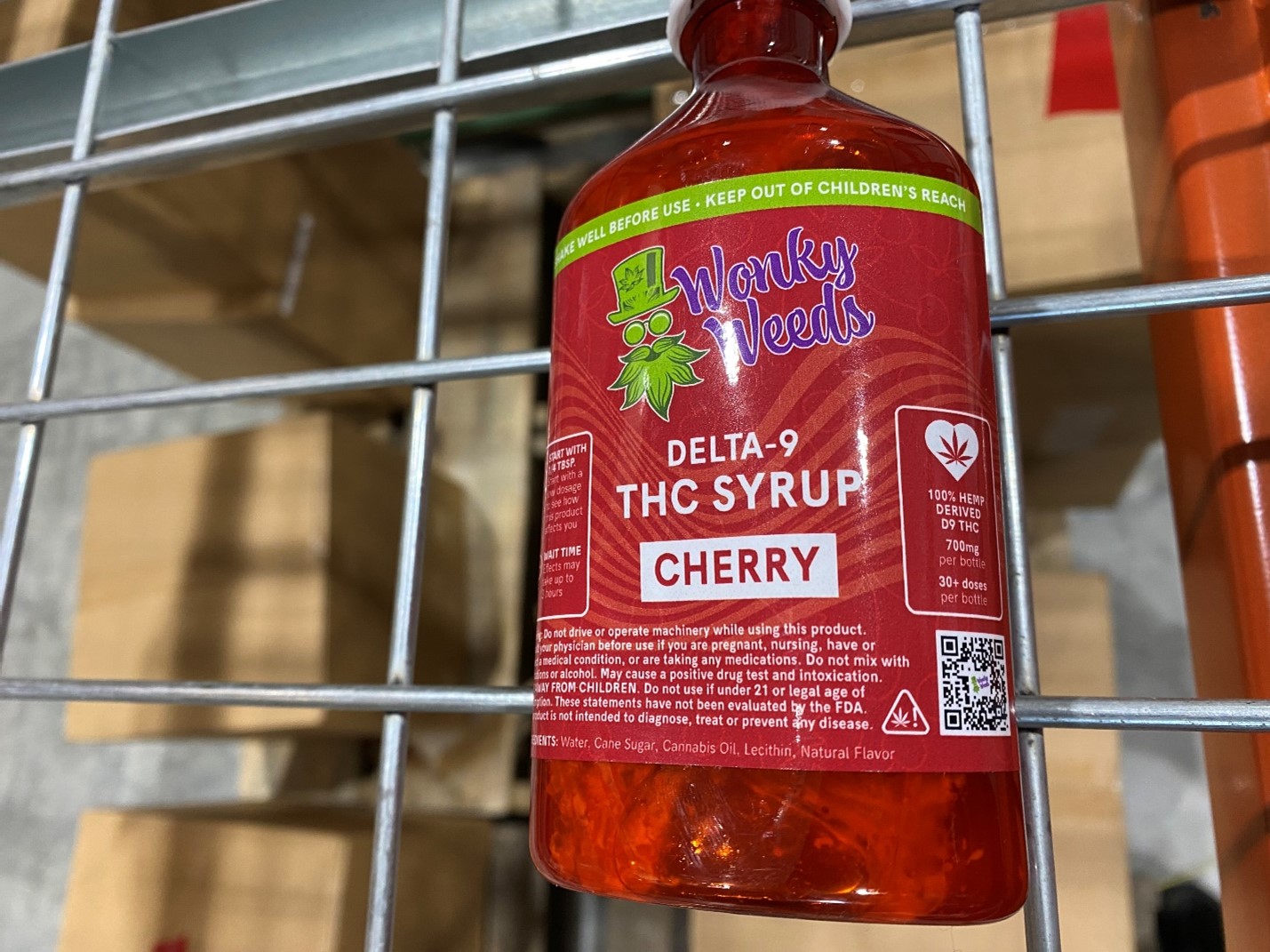 A bottle of Wonky Weeds-brand cherry-flavored delta 9 THC syrup, with visible mold growth in the bottle.