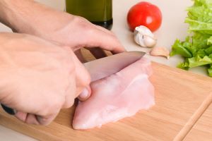 cutting chicken on cutting board