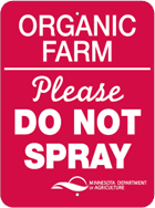 Red metal sign with the words Organic Farm Please Do Not Spray