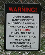 Sign that reads, "WARNING, UNATHORIZED TAMPERING WITH ANHYDROUS AMMONIA TANKS OR EQUIPMEN IS A FELONY PUNISHABLE BY A MAXIMUM SENTENCE OF 5 YEARS IMPRISONMENT AND A $50,000 FINE"