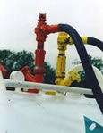 Two valves next to each other with hoses attached. The valves are different colors, one red, one yellow.
