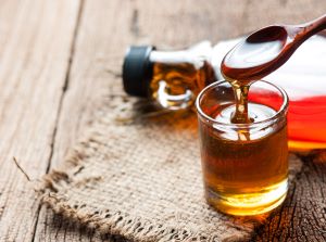 maple syrup jar and spoon full of syrup