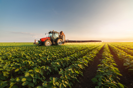 Tractor applying pesticide in a field of soybeans