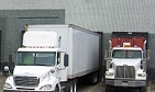 Two trucks parked at a distribution center