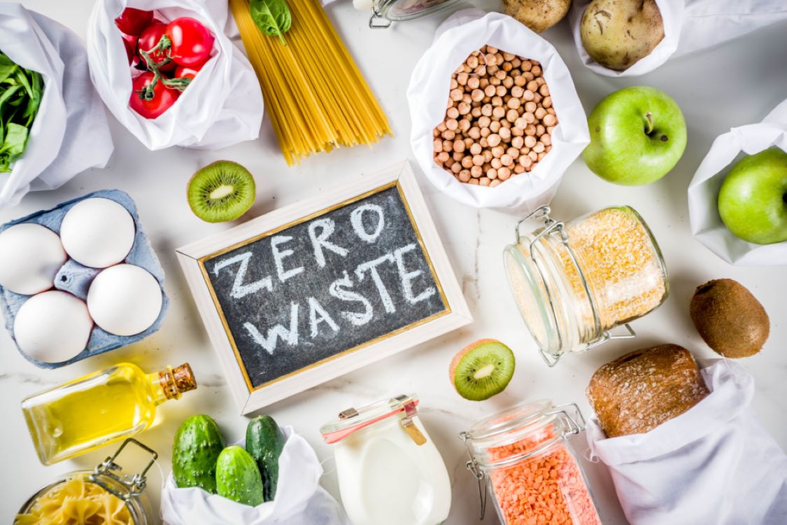 food laid out on a counter top with a zero food waste blackboard sign